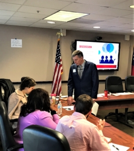 man speaking to other people at a table