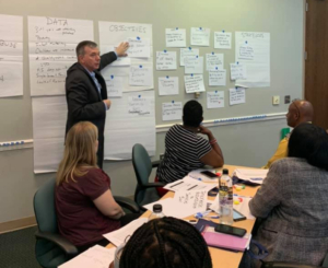 collective impact - man pointing to papers on a whiteboard