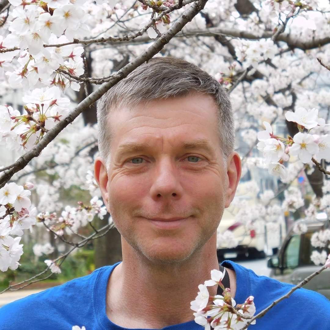 Chris photo with cherry blossom tree in background